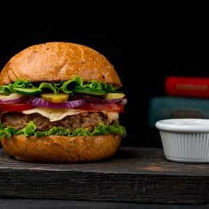 beef-cotlet-burger-with-sauce-on-a-wooden-board